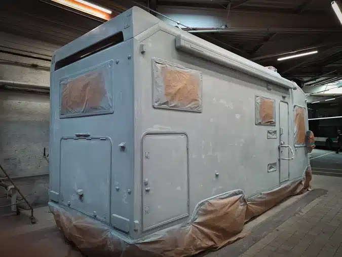 Peinture en cours sur un camping car dans notre cabine de peinture