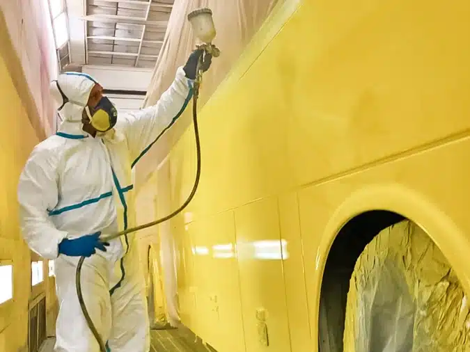 Peintre dans les ateliers Graphitruck en train de peindre un food truck