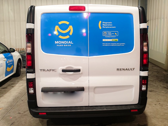 Pose de film vinyle covering sur un Renault Trafic en atelier Graphitruck