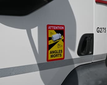 Pose d'un sticker d'angles morts lié au marquage sécuritaire