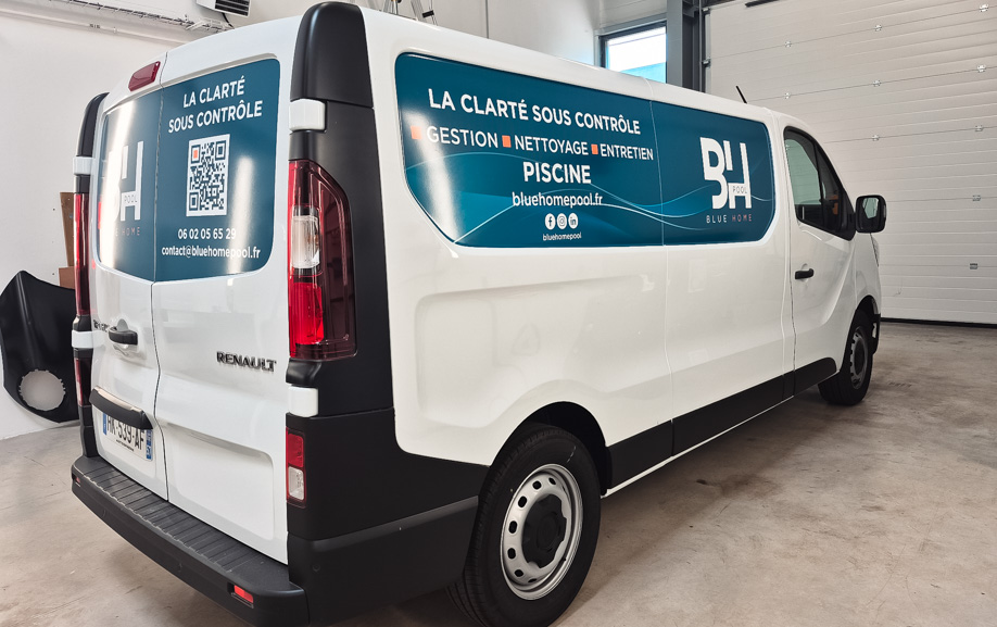 Covering Renault Trafic 3 Panneau imprimé posé sur le flanc d'un utilitaire blanc, avec logo et liste de services